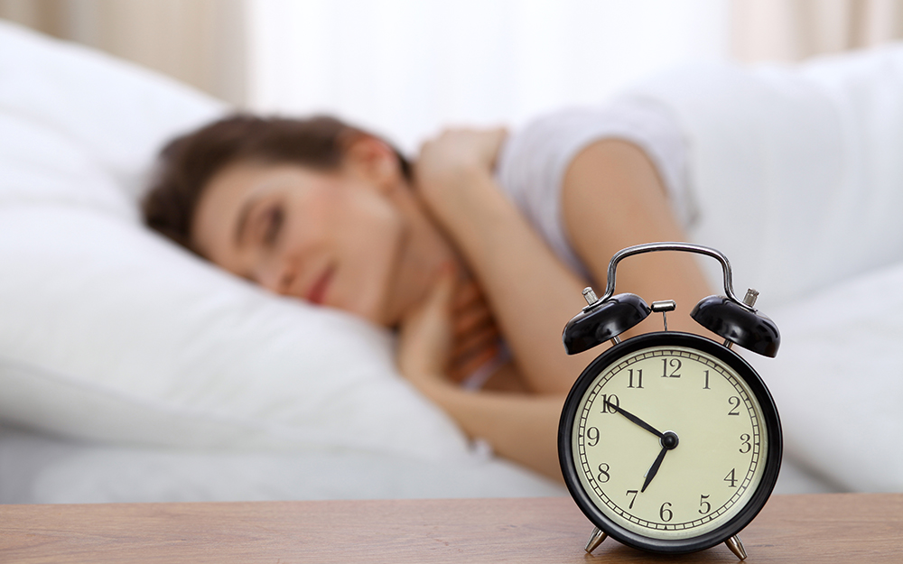 Alarm clock next to sleeping woman