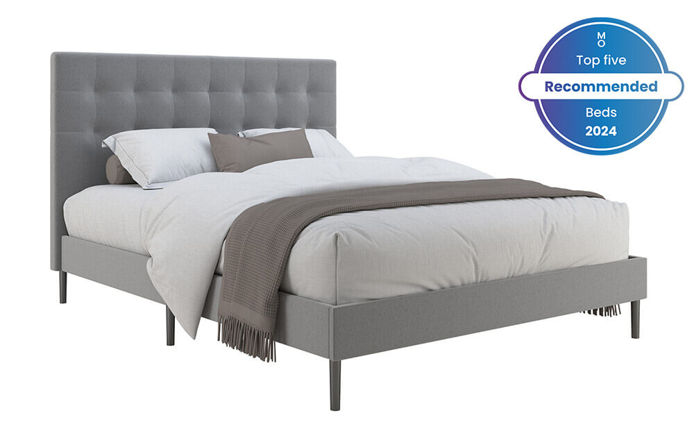 Image of the Novo Pandora Fabric Bed Frame with a duvet, blanket and pillows against a white background. Included in the image is a badge overlay stating that this mattress is one of Mattress Online's top five recommended beds of 2024.