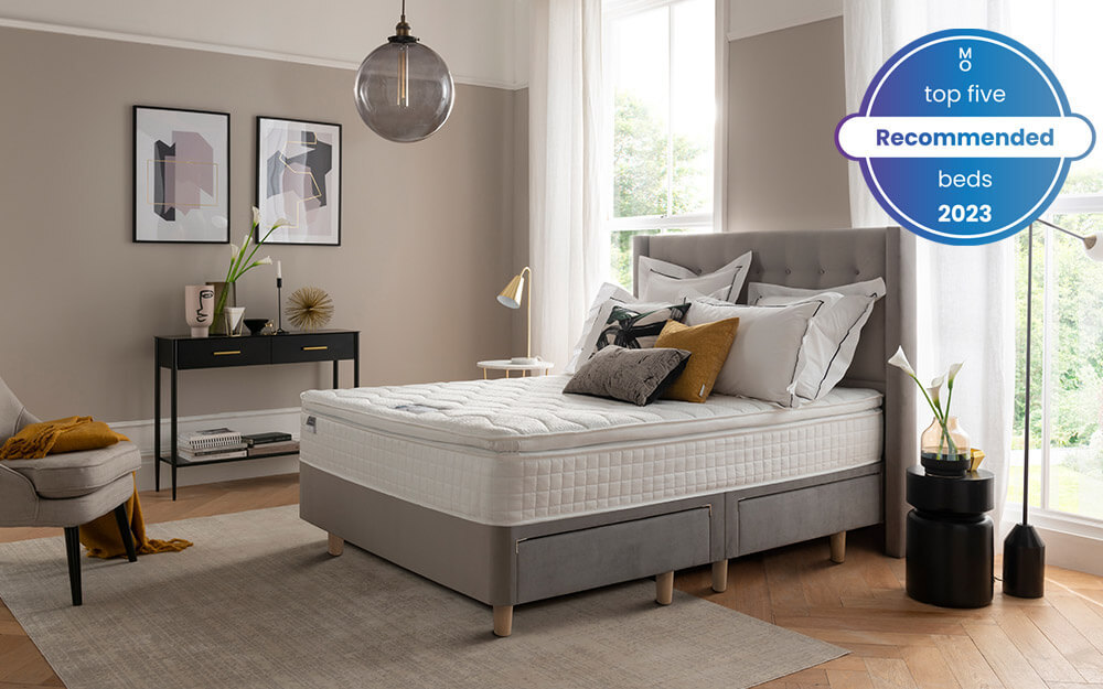 The Silentnight Bloomsbury Silver Velvet Bed Frame in a large bedroom in front of tall windows - one of our Top 5 Recommended Beds 2023