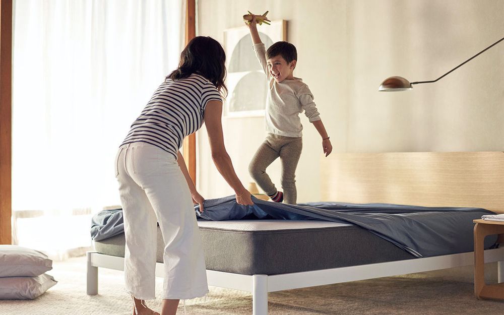 Woman removing bedding from mattress