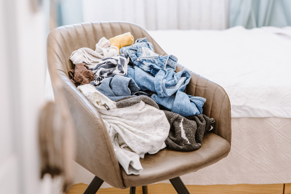 Chair with a pile of clothes on top of it