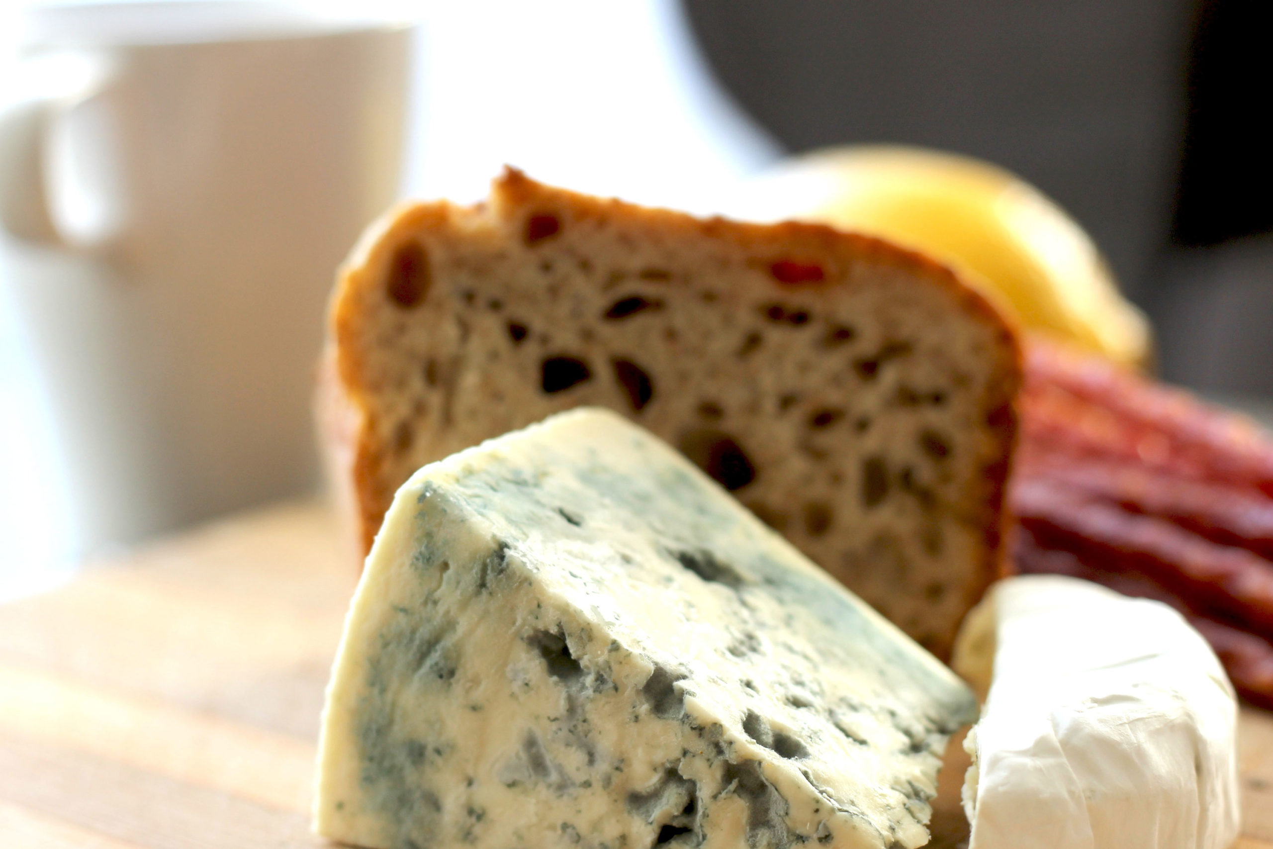 Stilton cheese with bread and a mug in the background