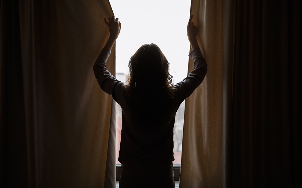 Woman closing curtains