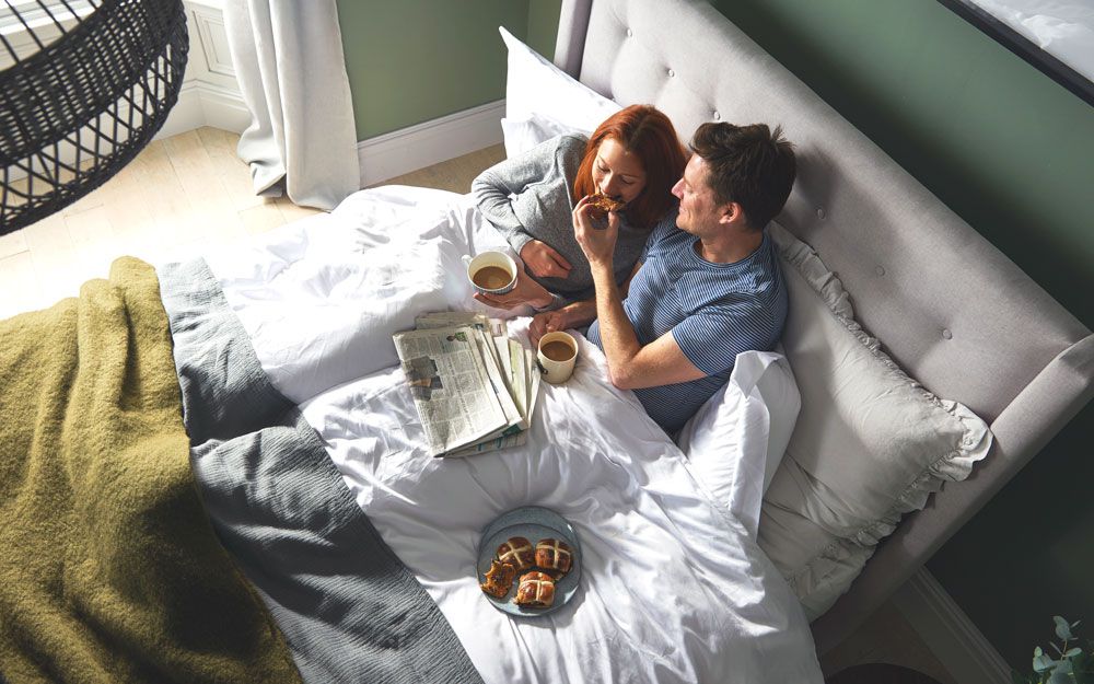 Young couple enjoying breakfast in bed