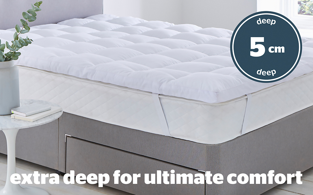 The Silentnight Luxury Deep Sleep Ultimate Mattress Topper on a Silentnight mattress and divan bed. The text overlay says '5cm deep' and 'Extra deep for ultimate comfort'.