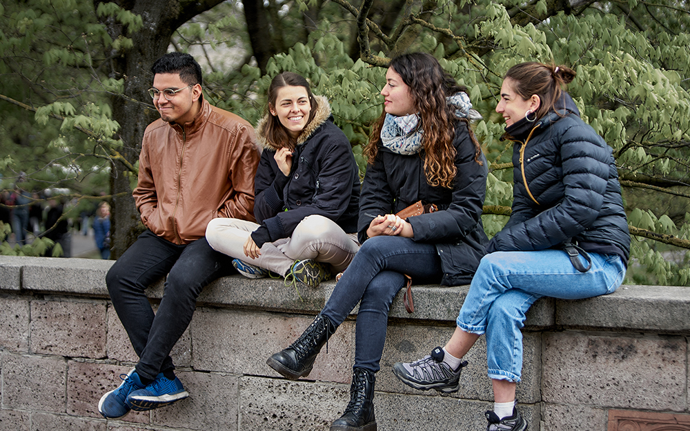 Friends sat talking on a wall