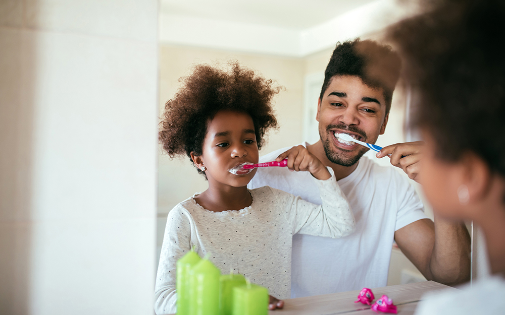 Dad and daughter brushing teeth before bed