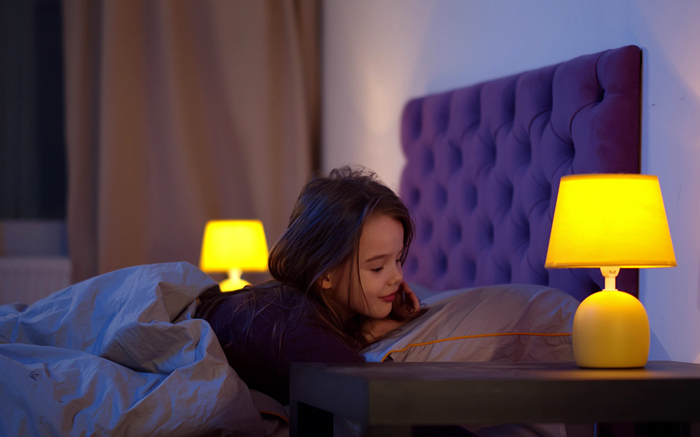 Girl in bed waking up with a lamp