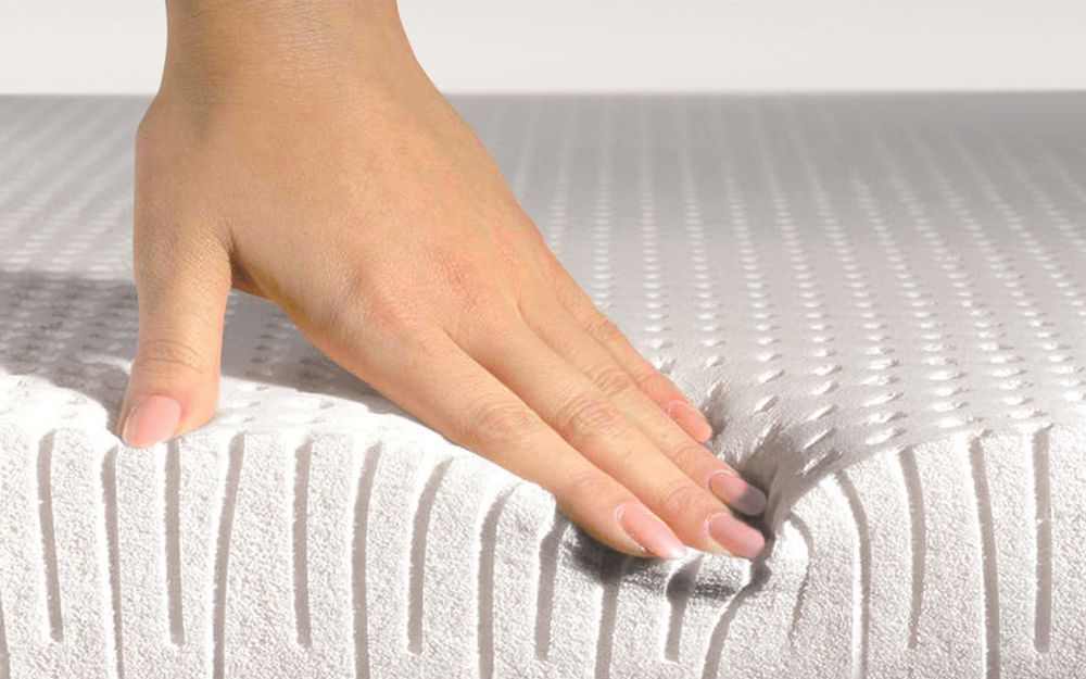 Hand presses on a latex foam mattress