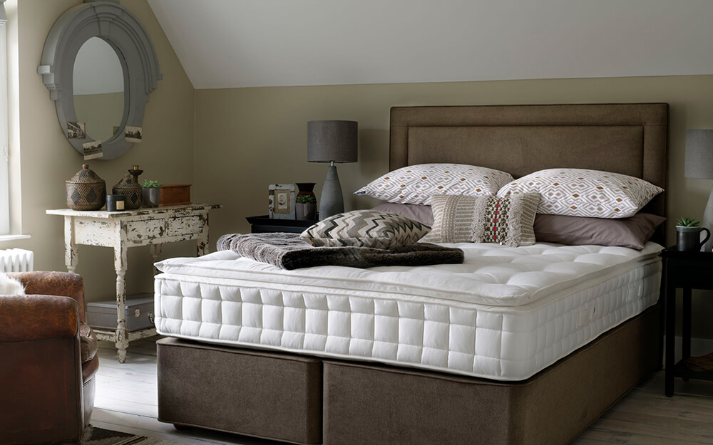 The Hypnos Fairford Pillow Top Supreme Mattress on a brown bed in an antique bedroom