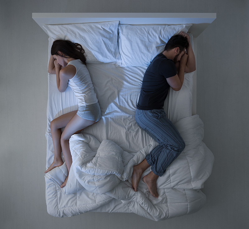 Man and woman sleeping with backs to each other