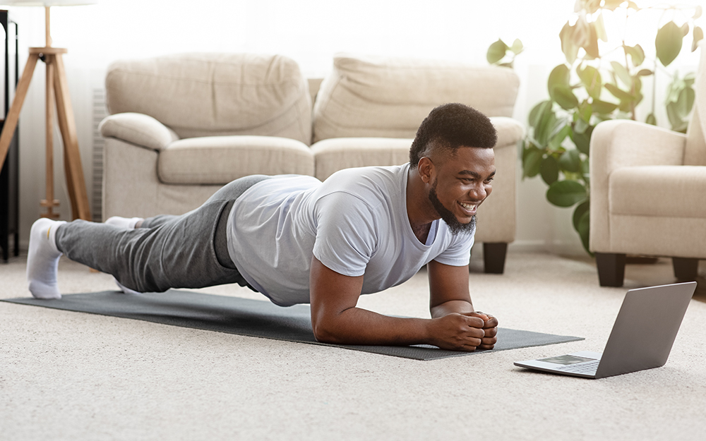 Man exercising in front of laptop