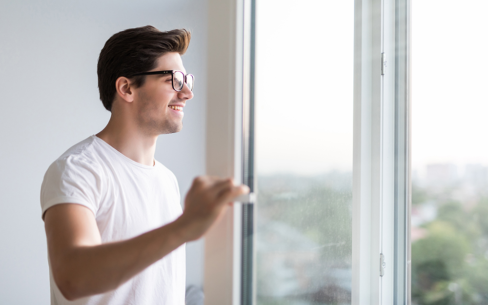 Man opening window in the morning