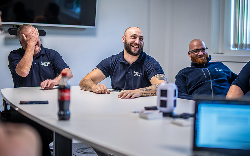 The Mattress Online warehouse team laughing while in a meting