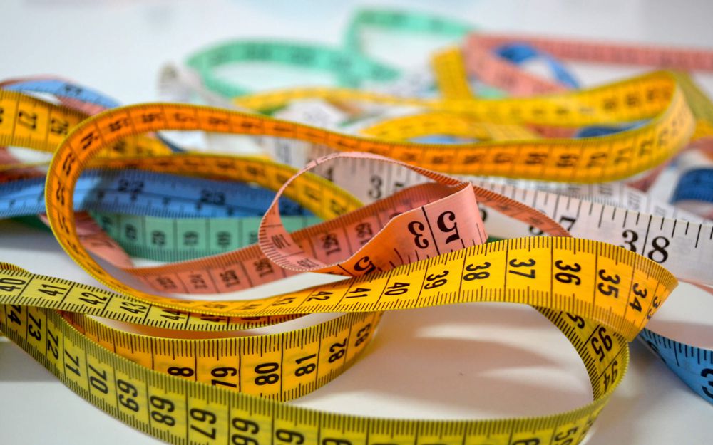 A close shot of several measuring tapes laid down together.