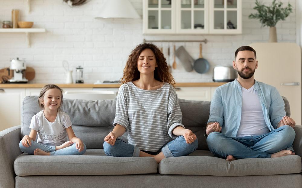 A family sitting on the sofa and meditating