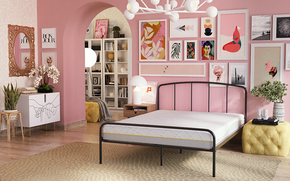 The Memory Zone 1000 Pocket Mattress on a black metal bved in a bright pink room with lot of pictures on the walls.