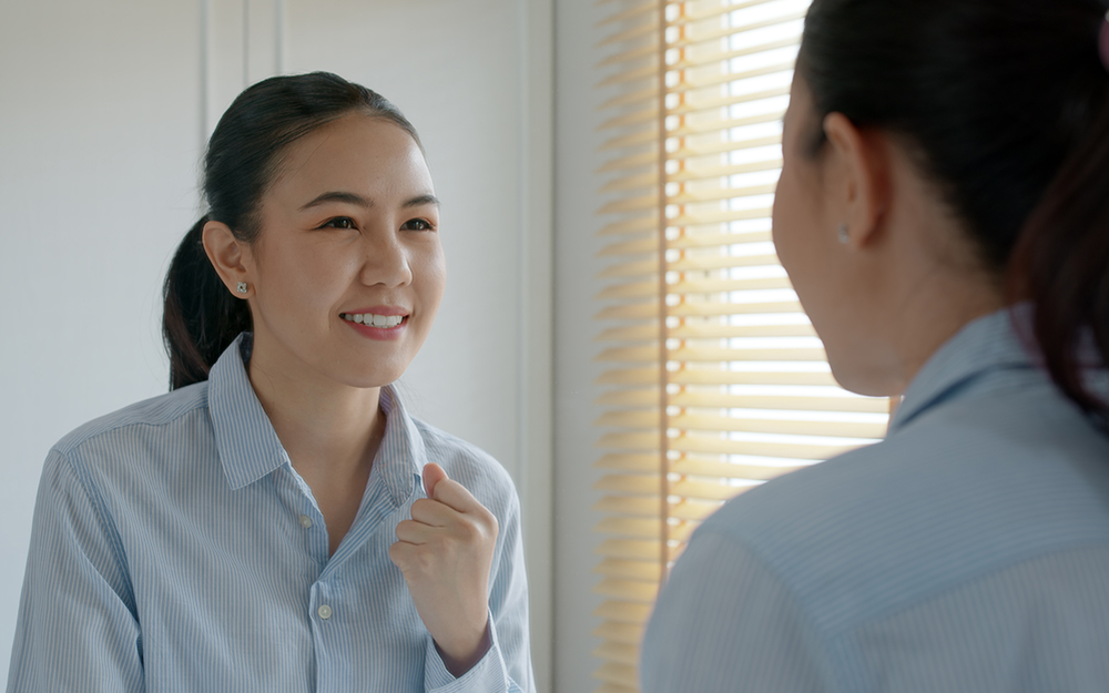 Woman fist pumping in mirror.