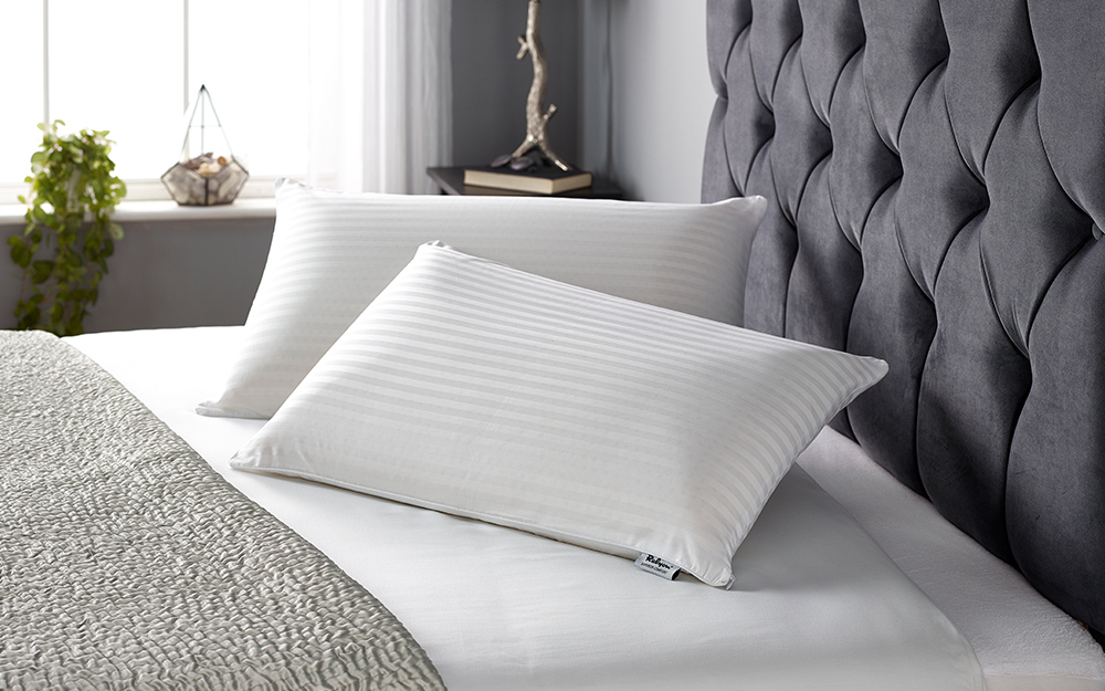 Relyon Superior Comfort Slim Latex Pillows dispalyed on a velvet bed.