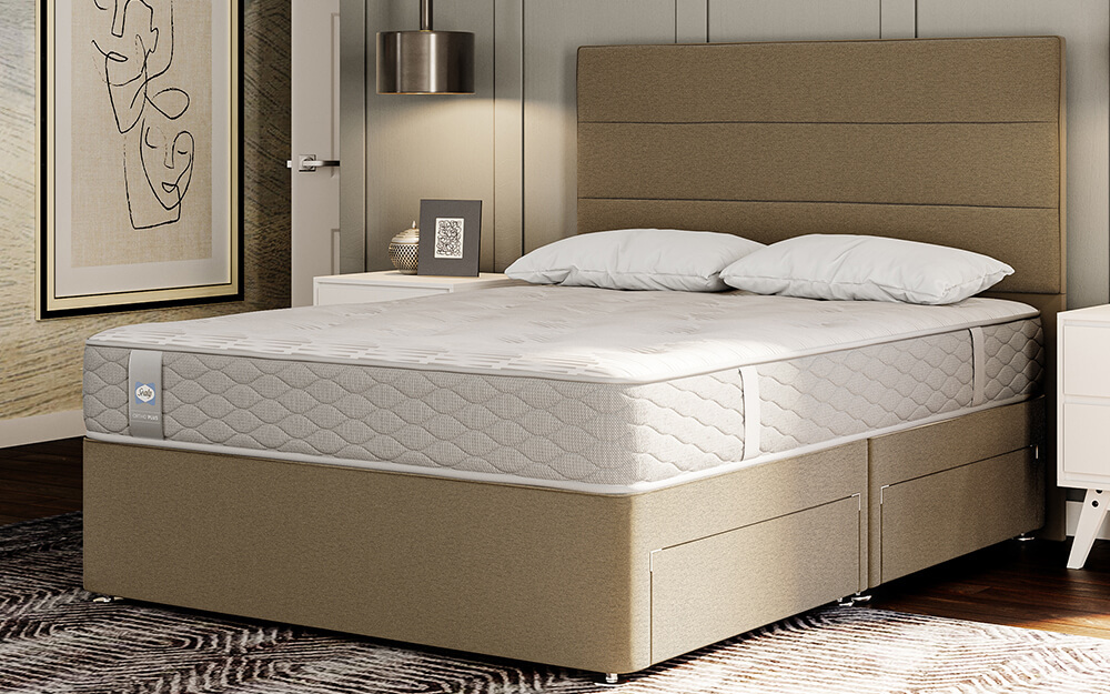 The Sealy Eaglesfield Memory Ortho Plus Mattress on a beige divan bed in a hotel room.