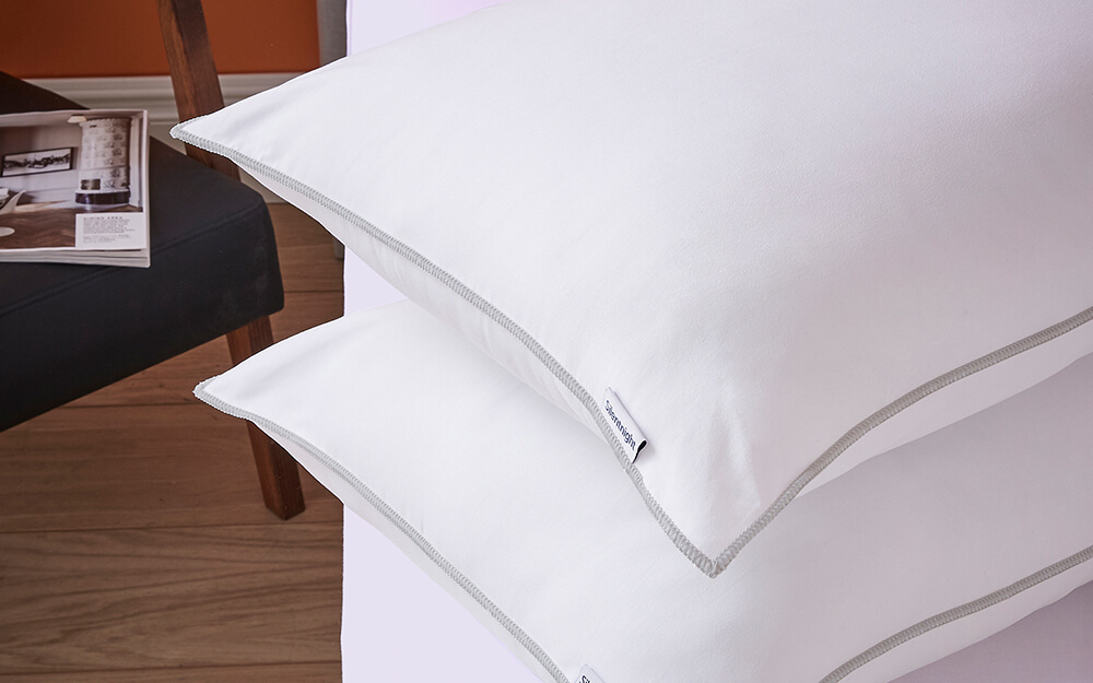 Silentnight Deep Sleep Pillow Pair stacked on a white bed