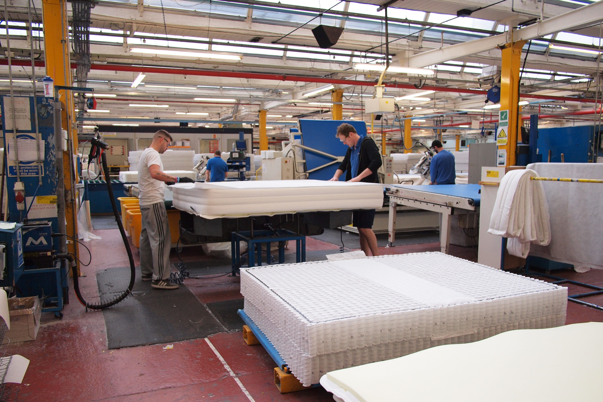 Workers adding the comfort layers to a Silentnight Mirapocket mattress