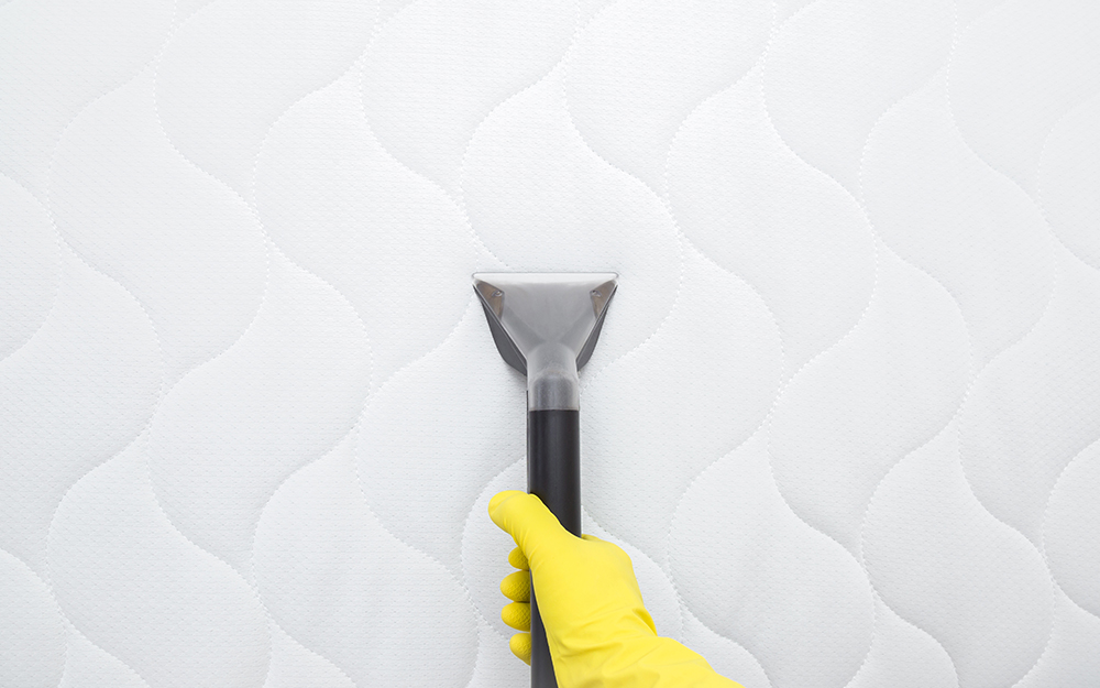 Woman steam cleaning a mattress