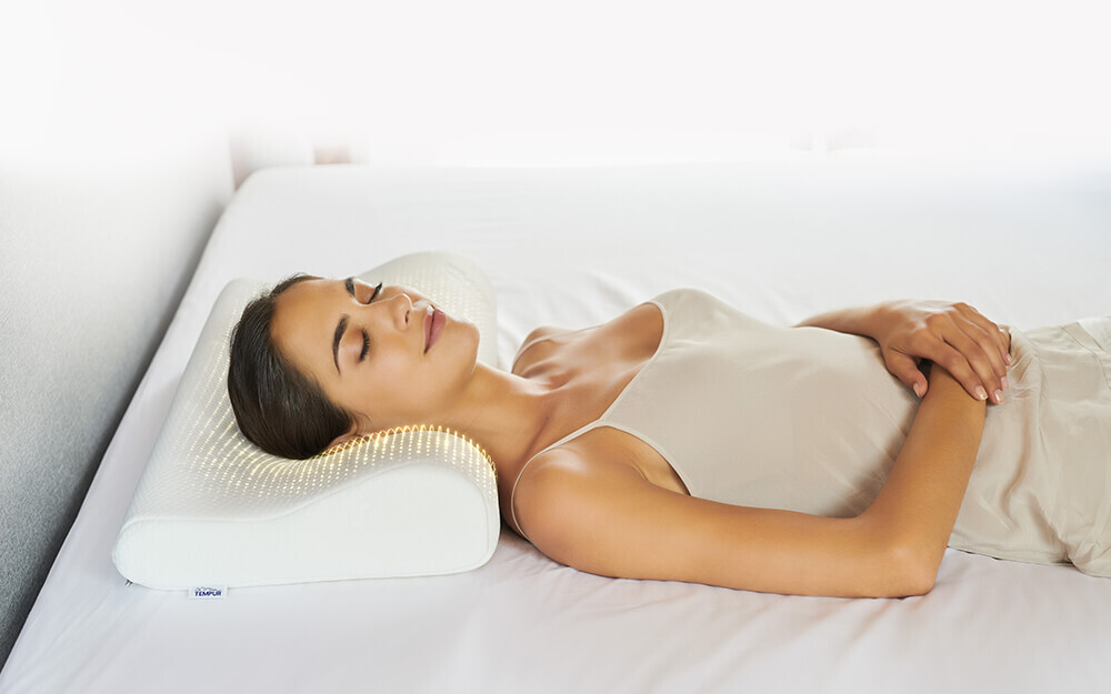 A woman laying on the TEMPUR Original Pillow