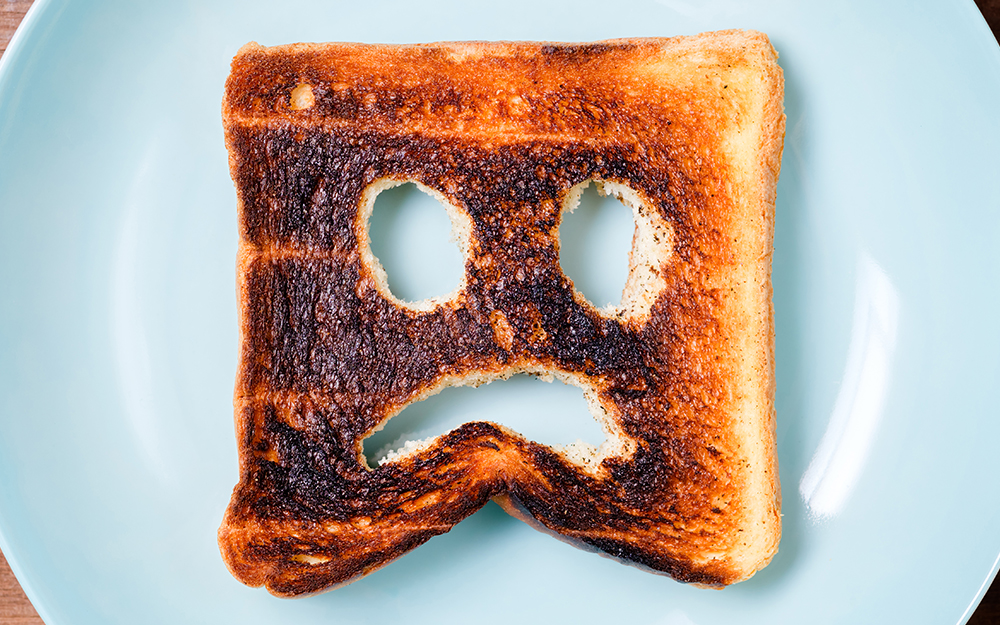 Piece of toast with a sad face cut out.