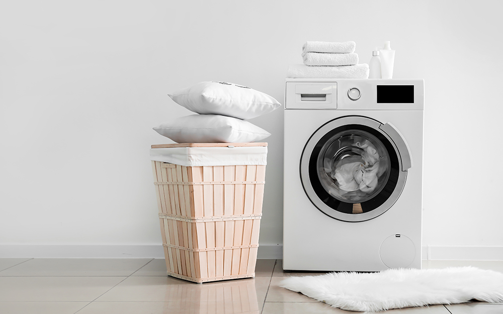 A washing machine with a pile of pillows