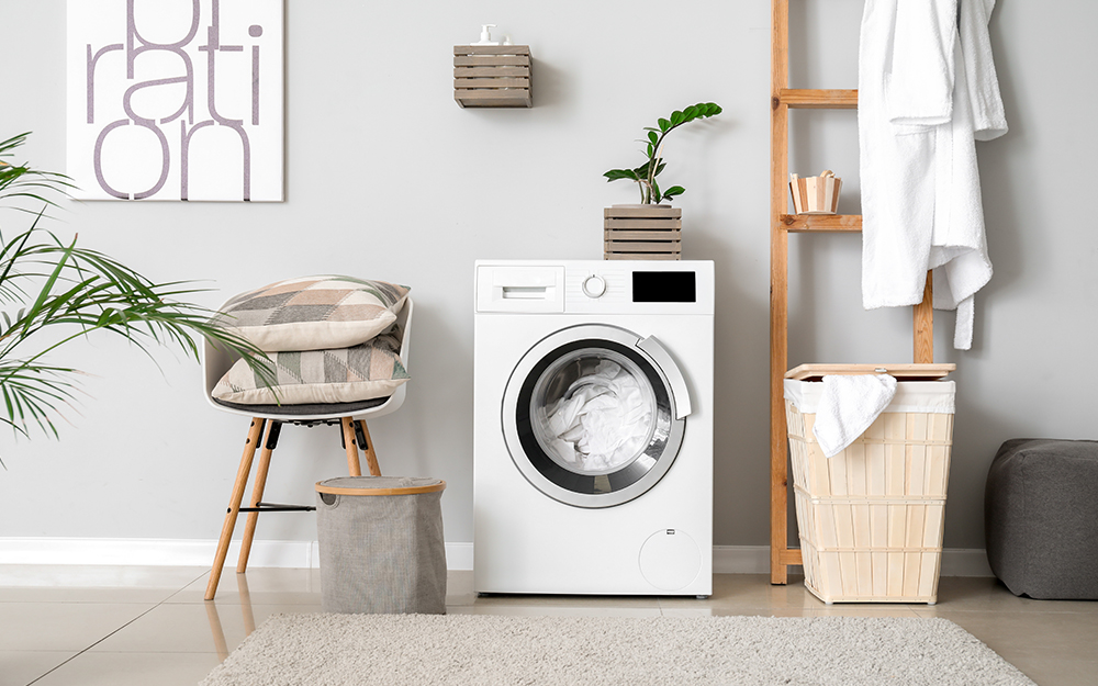 A washing machine in a grey utility room