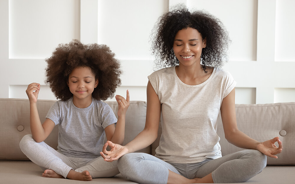 Mother and daughter meditating together