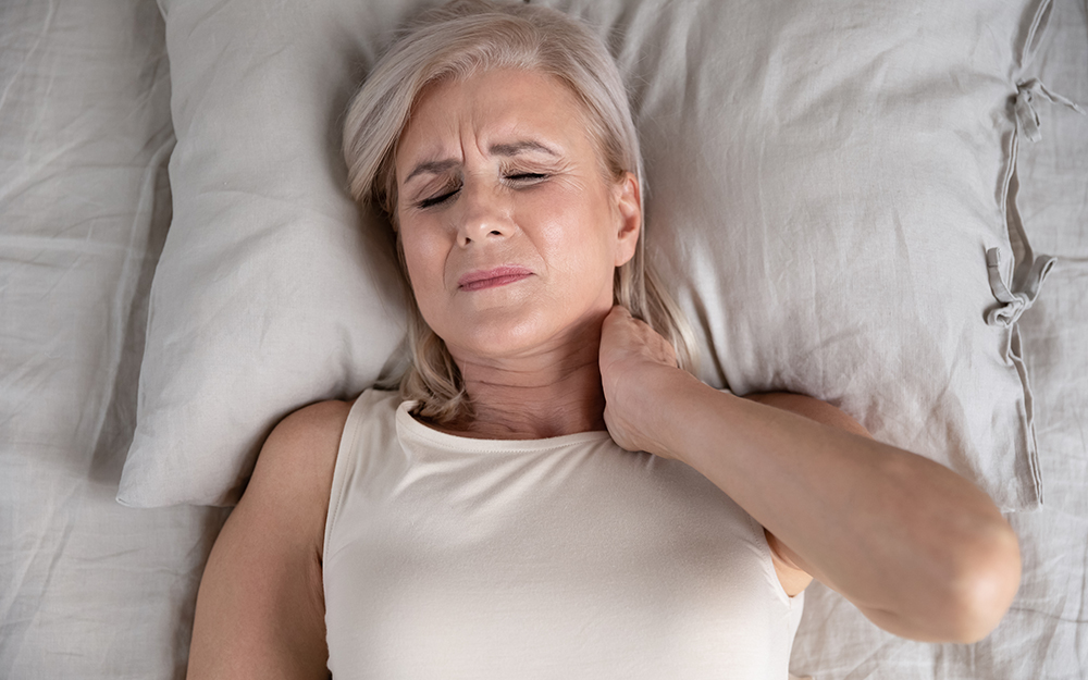 A woman holding her neck in pain