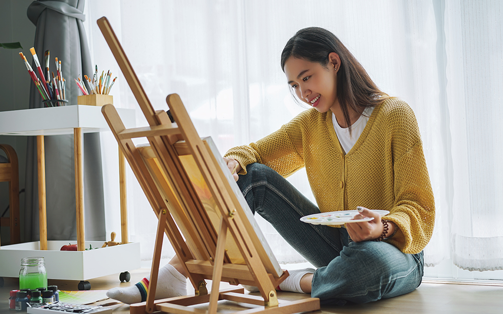 Woman painting in her bedroom