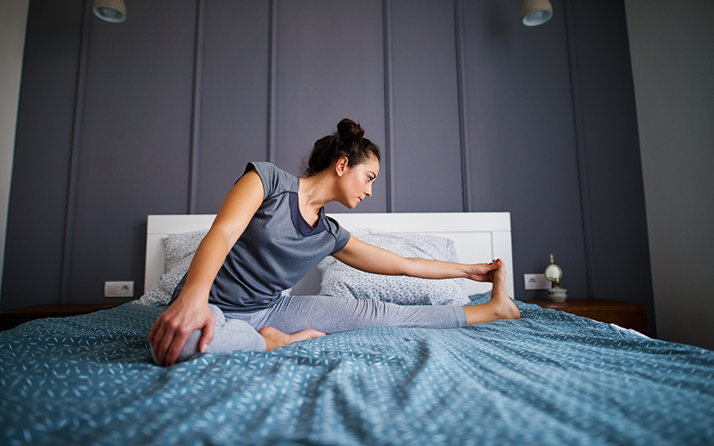 A woman stretching on a bed