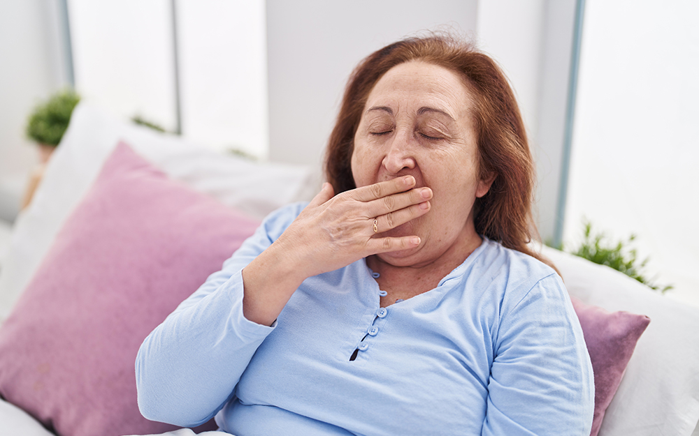 Middle aged woman yawning on a sofa