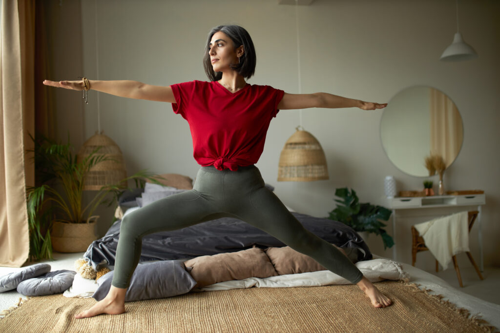 Woman practicing yoga in her bedroom