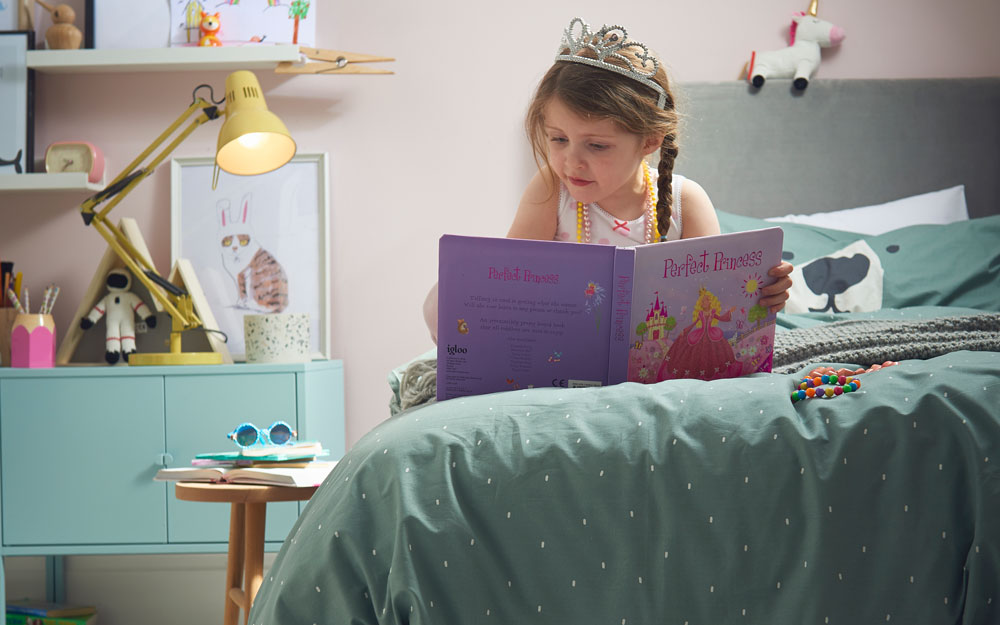 Child reading in her own bed